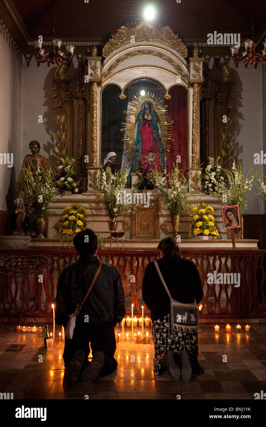 Los indígenas tzotziles par dentro de una iglesia rezando con muchas velas en San Cristóbal de