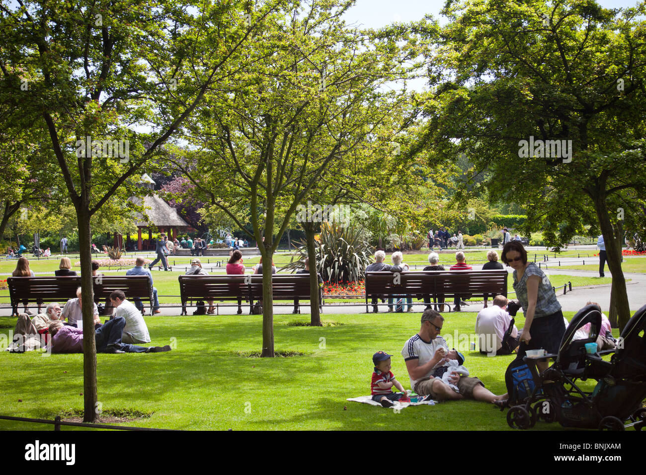 Las personas relajante sobre el césped durante el almuerzo en el parque St Stephen's Green, Dublín, Irlanda Foto de stock