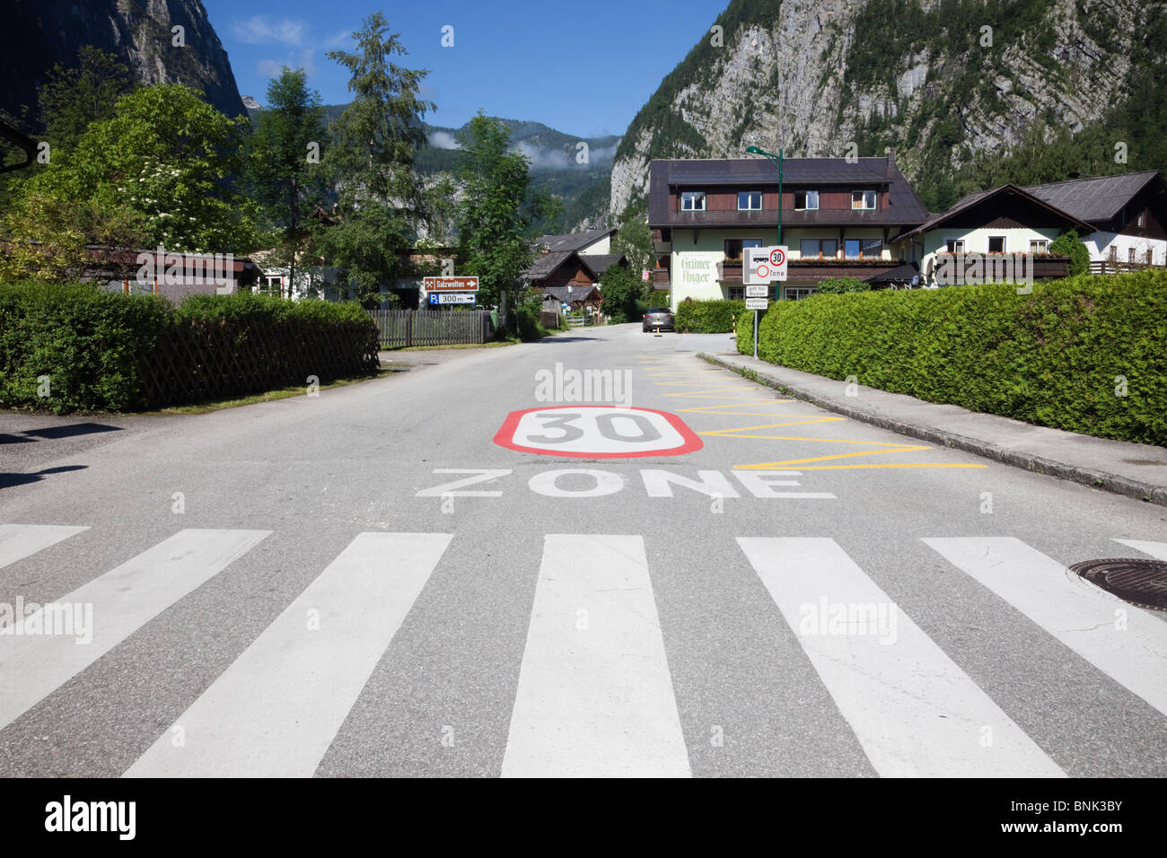 Austria, Europa. Cruce peatonal y treinta kilómetros por hora de la zona de restricción de velocidad firmar en la carretera Foto de stock