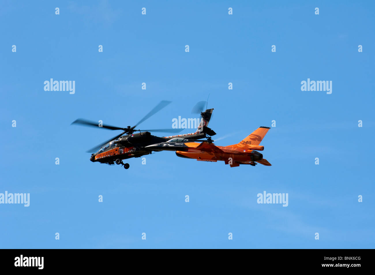 Royal Netherlands Airforce Boeing AH-64D Apache y General Dynamics F16-AM combates Falcon volar juntos Foto de stock
