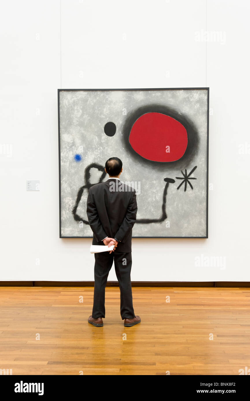 Hombre mirando el arte moderno óleo de Joan Miró en el Museo Nacional de Arte Occidental, Tokio, Japón Foto de stock