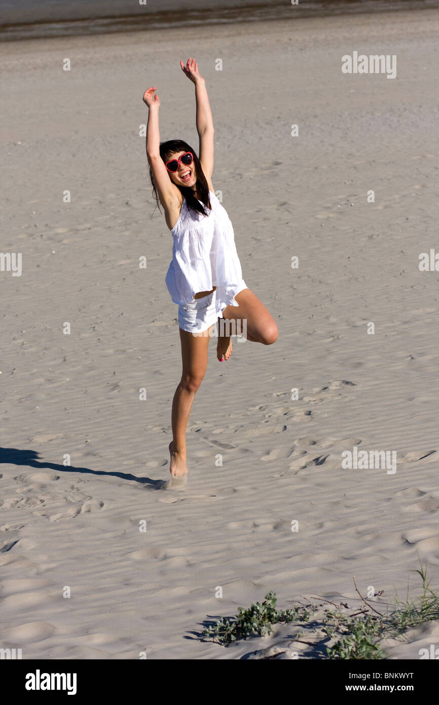 Atractiva mujer joven está bailando en la playa Foto de stock