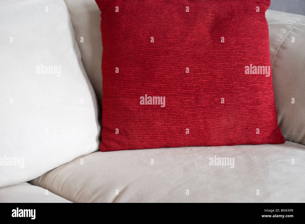 Las almohadas blancas y rojas descansan sobre los cojines del sofá, en Corona, Nuevo México. Foto de stock