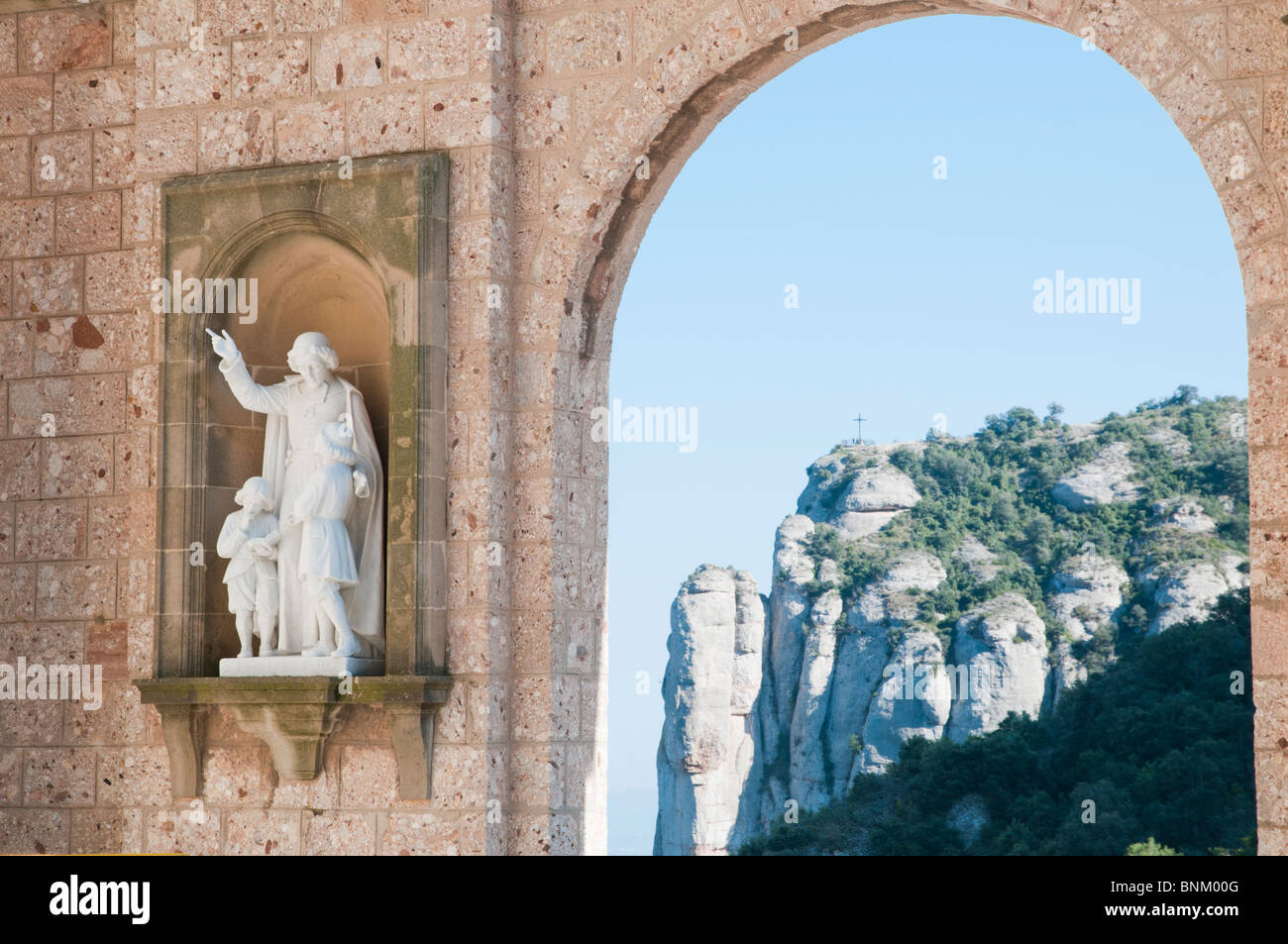 Estatua católica de pertinencia de personas en la explanada principal del santuario de Montserrat, centro religioso de Cataluña, España Foto de stock