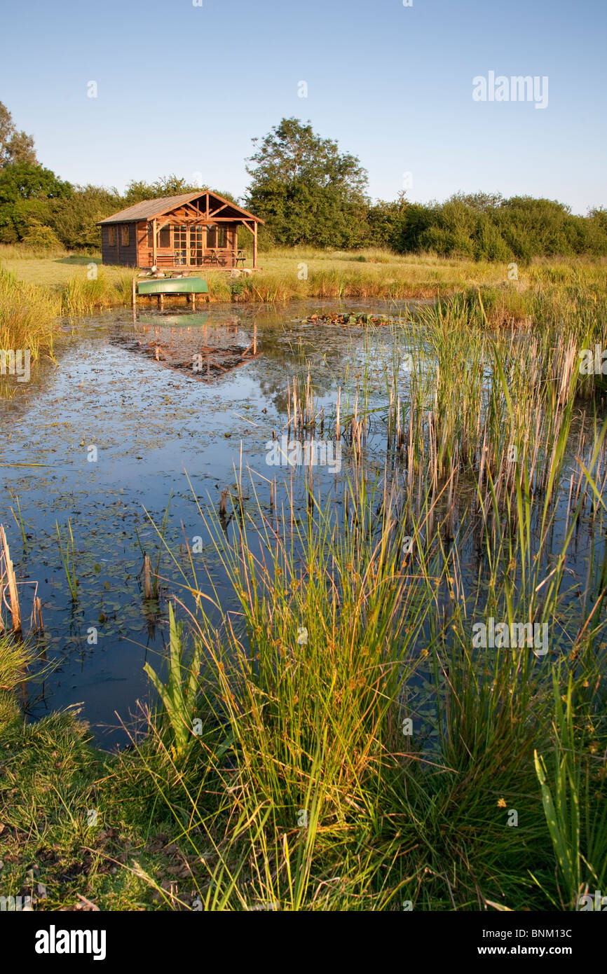 Gran estanque y casa de veraneo, como en el campo, en Wiltshire, Inglaterra Foto de stock