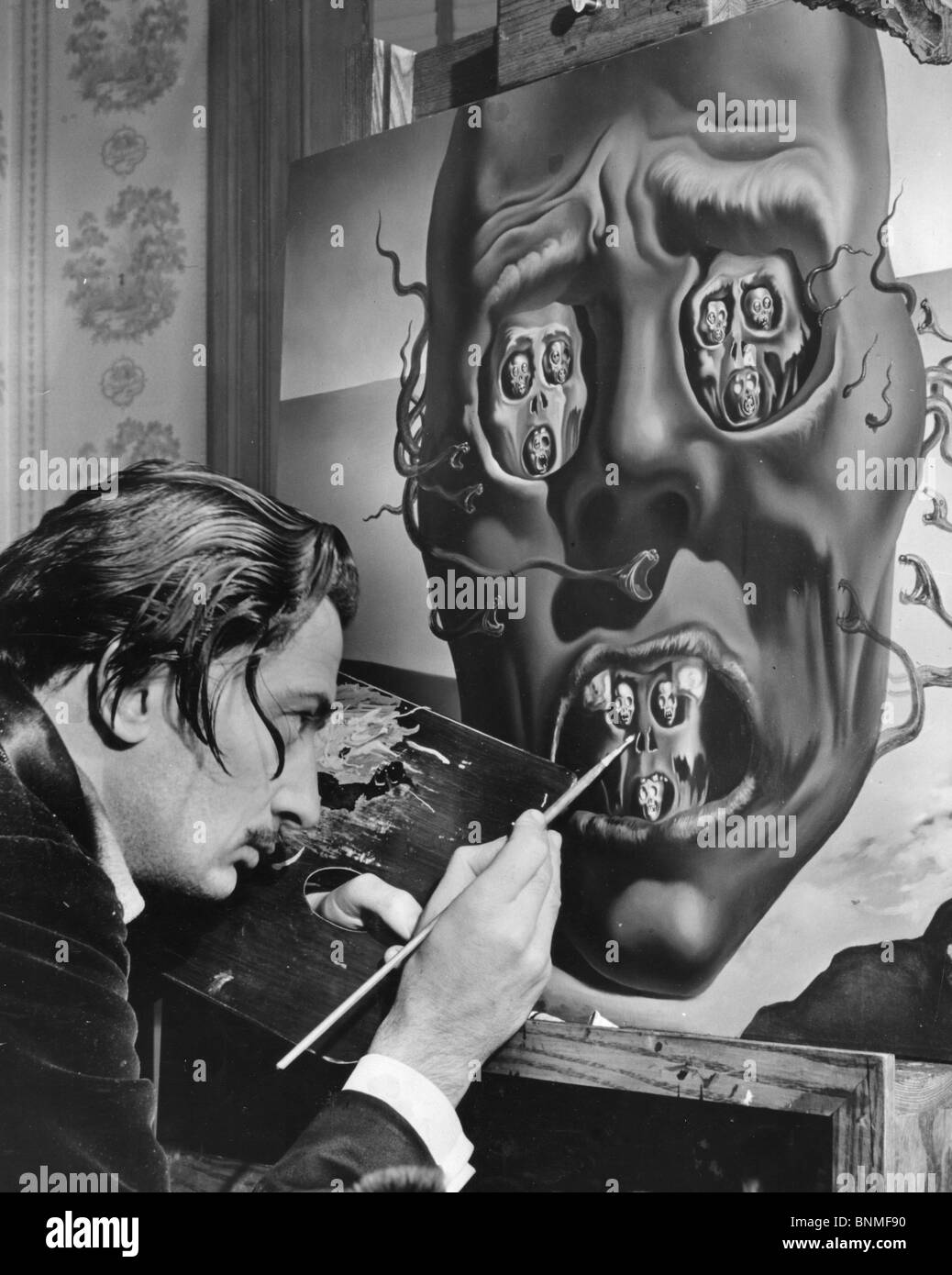 SALVADOR DALÍ (1984-1989), artista español trabajando en su pintura de la cara de la guerra en los EE.UU. en 1940 - véase la descripción a continuación. Foto de stock