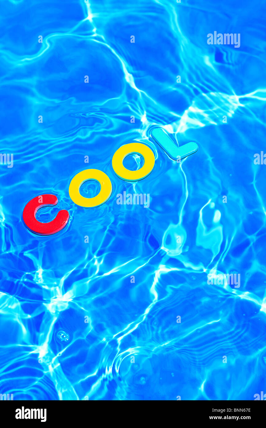 La palabra fresca hecha de espuma letras flotando sobre la superficie del agua de una piscina Foto de stock