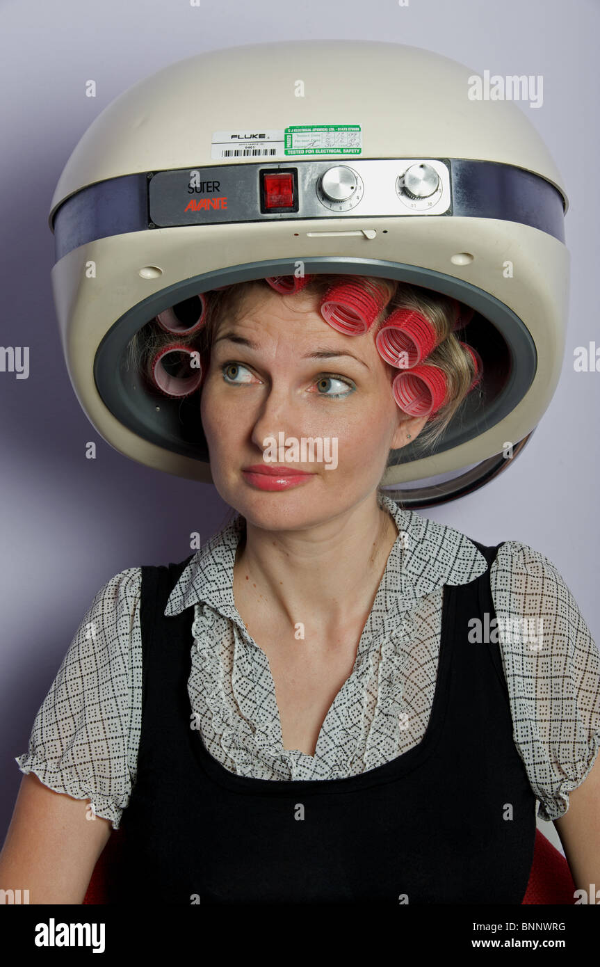 Mujer en rulos bajo secador de pelo Fotografía de stock - Alamy