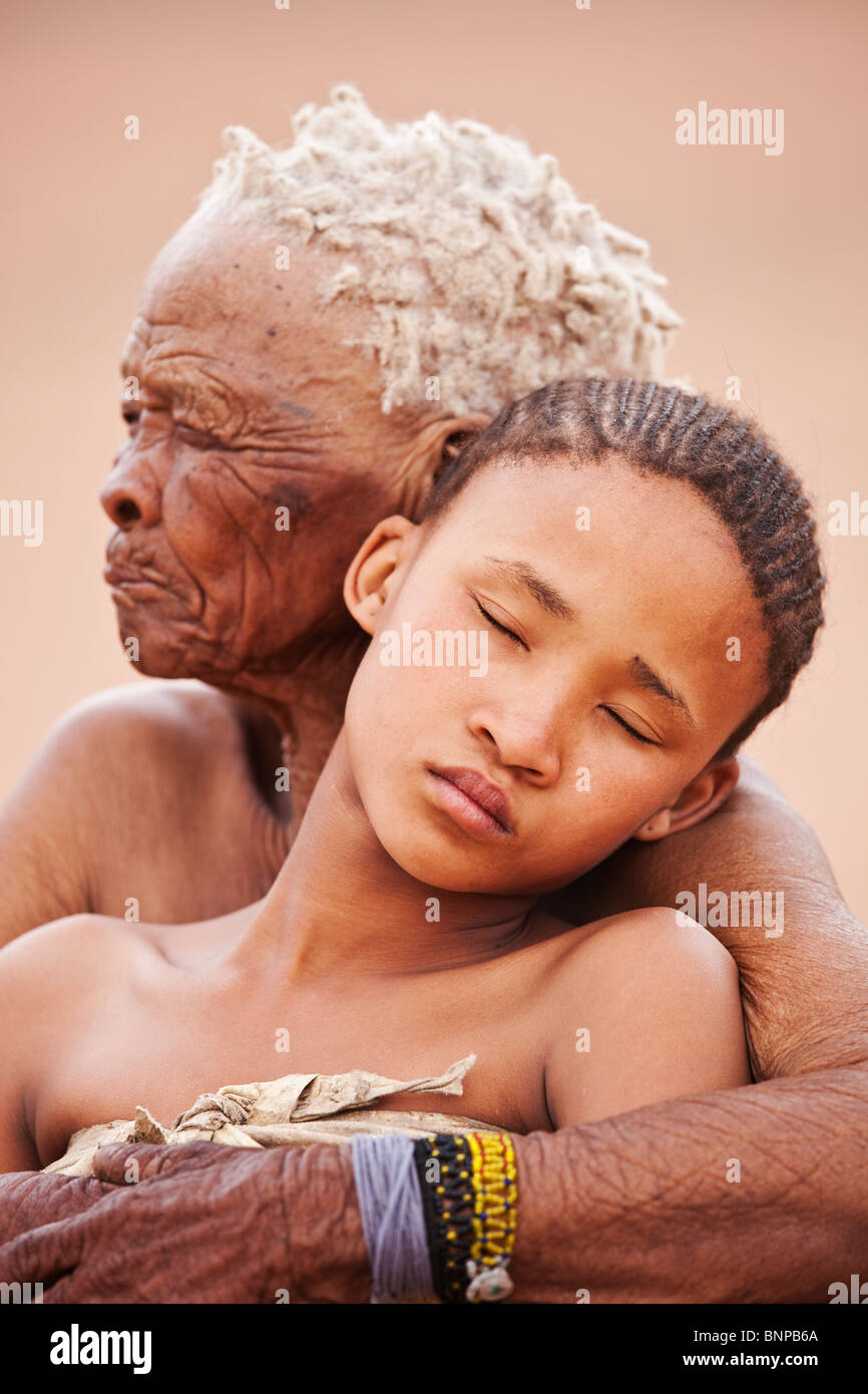 Bushman/pueblo San. Muchacha con anciana abrazando Foto de stock