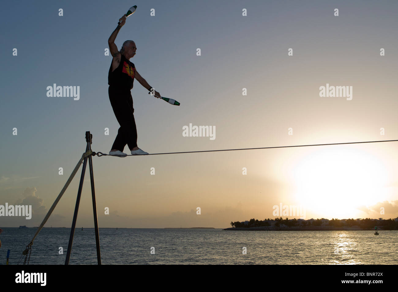 Famosa Sunset Celebration, Key West, Florida. Ejecutante de la calle, Soto sobre el alambre alto. Foto de stock