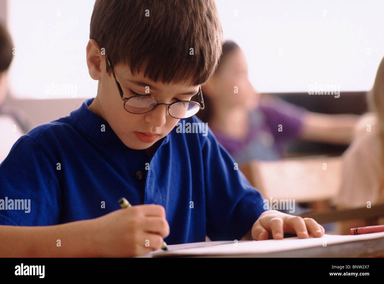 Estudiante de primaria colorear con crayón. Foto de stock