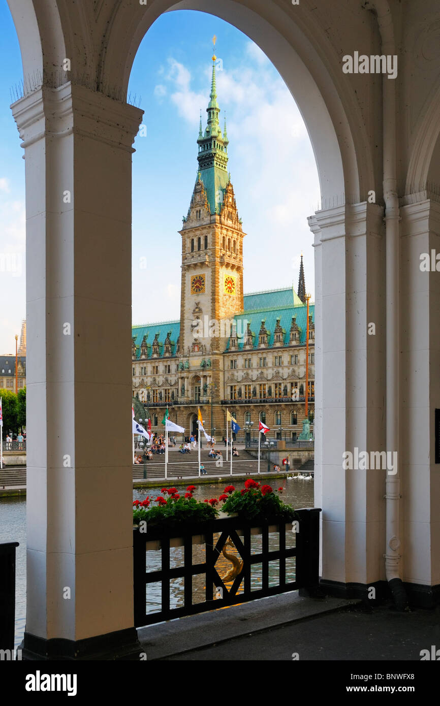 La noche, el sol brillaba en la torre del reloj del ayuntamiento de Hamburgo, Alemania. Foto de stock