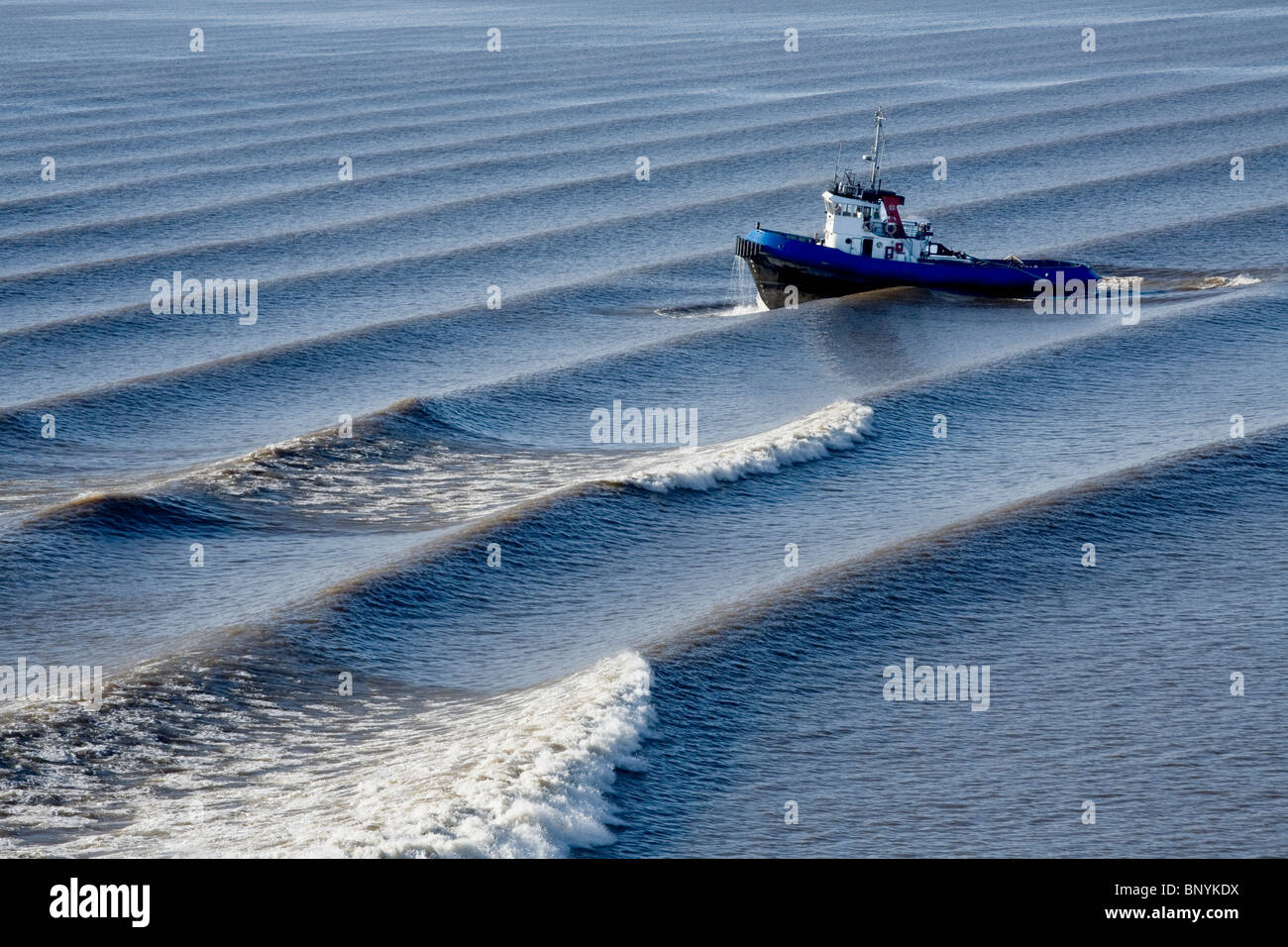 Remolcador navegando en el océano durante varios despierta día soleado océano azul Océano Pacífico Foto de stock