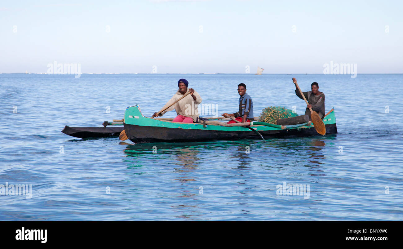 Tres pescadores Vezo en su piragua / canoa Outrigger, fuera de su aldea de Anakao,al sur-oeste de Madagascar Foto de stock