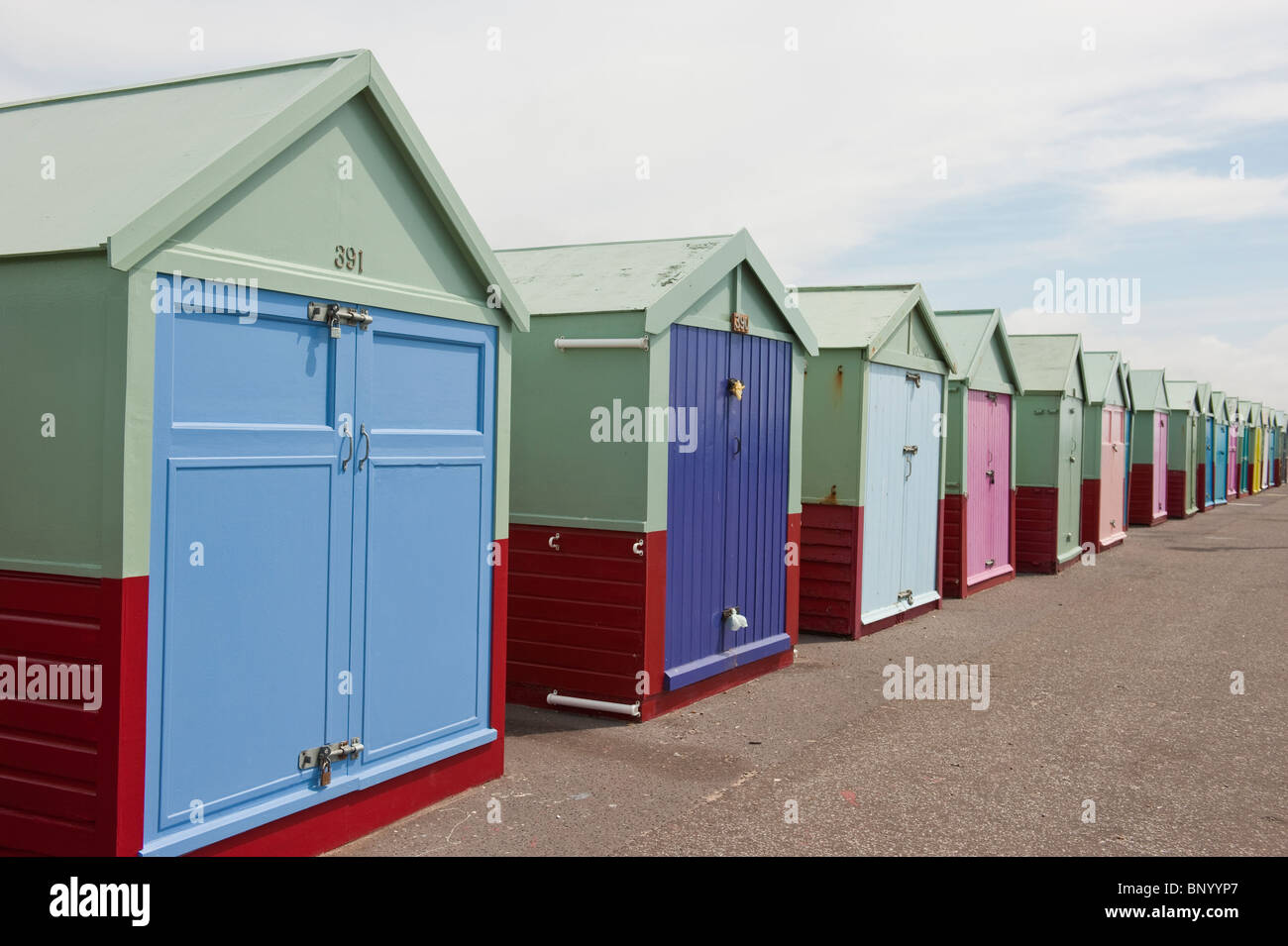 Fila de coloridas casetas de playa en el paseo marítimo, de Hove, East Sussex. Foto de stock