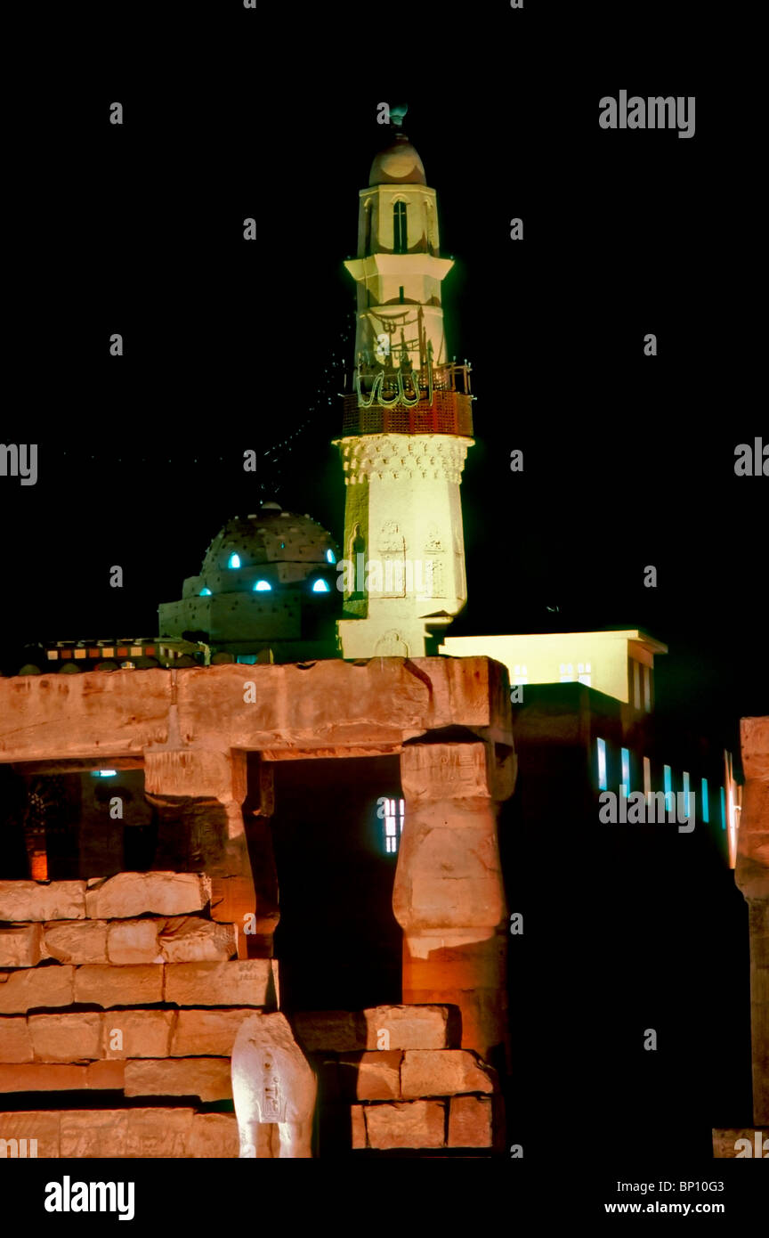 Louxor, Egipto, Vista de Louxor templo, iluminado por la noche. Mezquita en la parte posterior de la torre del templo. Foto de stock