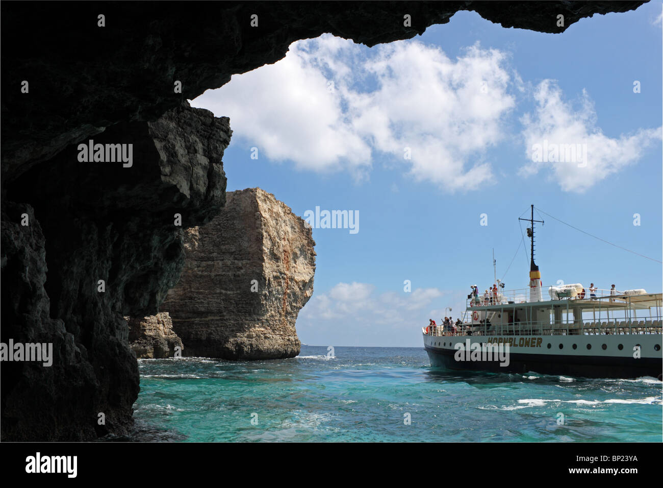 Excursión en barco Hornblower visto desde el interior de la cueva de Smugglers' Cove, debajo de Marfa Ridge, cerca Mellieħa, norte de Malta, el Mediterráneo, Europa Foto de stock
