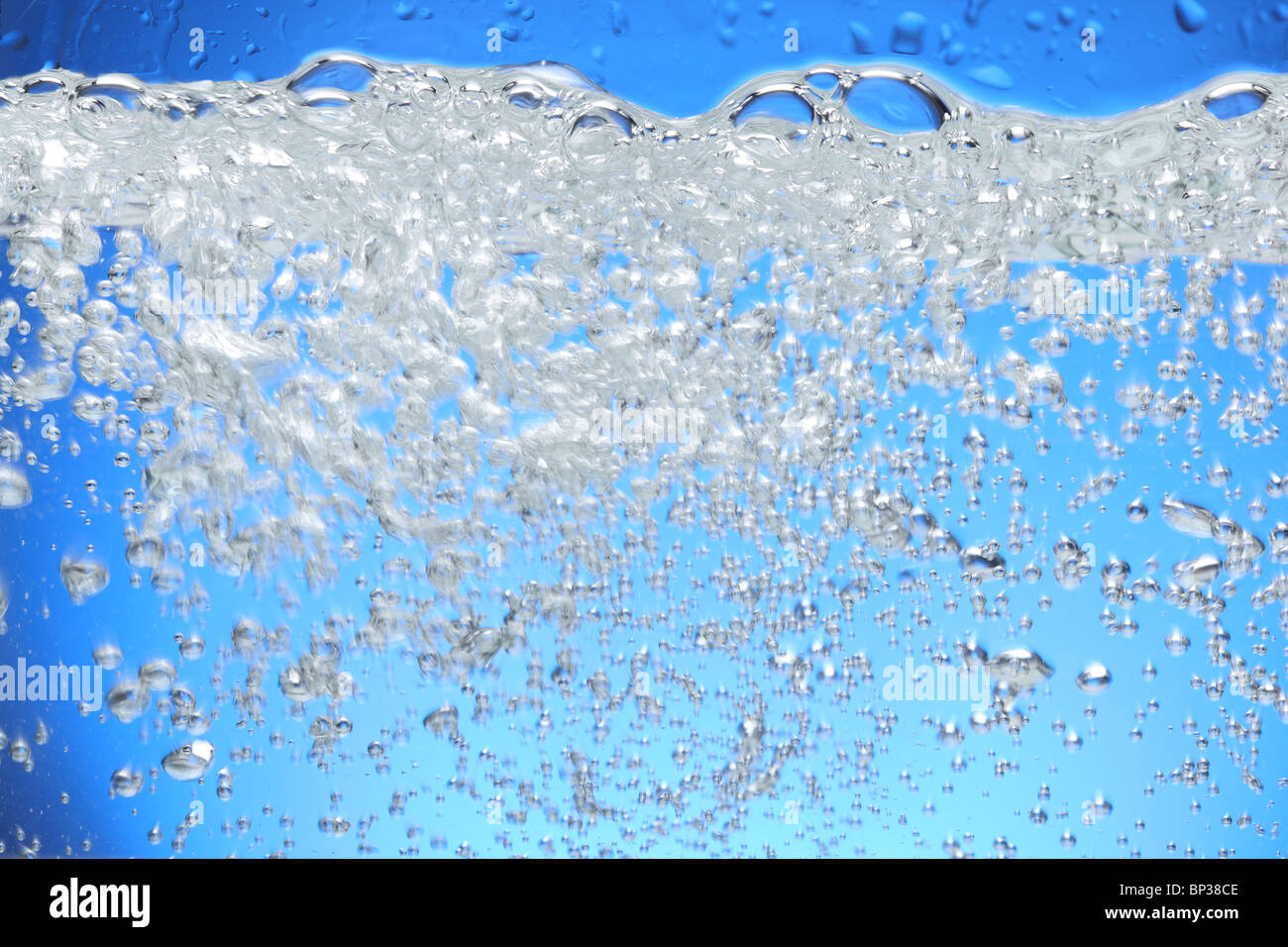 Las burbujas de aire se elevan desde la superficie del agua. Foto de stock