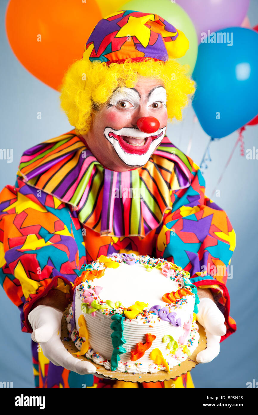 Feliz cumpleaños payaso sosteniendo un pastel de cumpleaños. Pastel