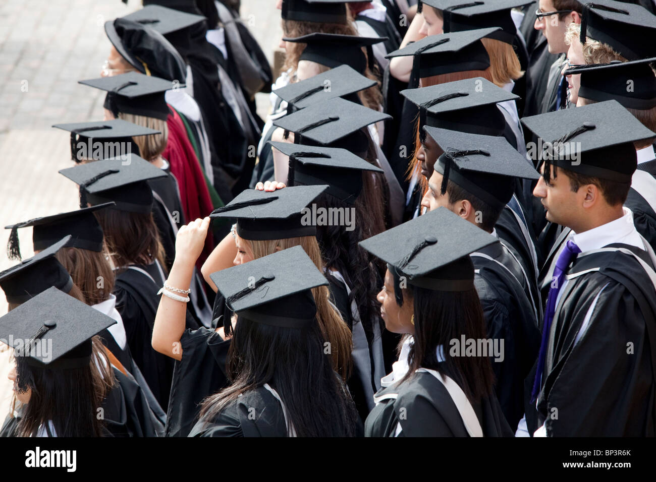 Los graduados a la espera de ser fotografiado tras una ceremonia de grado en la Universidad de Birmingham en el REINO UNIDO Foto de stock