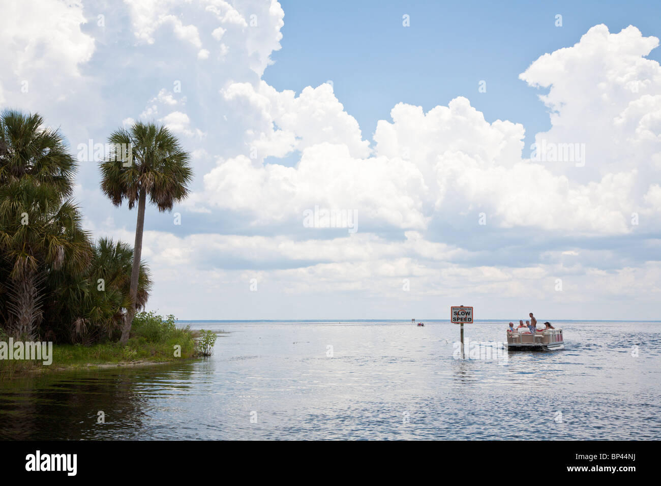 Lake George, FL - Mayo 2010 - Pontoon Boat pasa "Baja Velocidad" signo entrando en el río Salt de Lake George en la Florida central Foto de stock