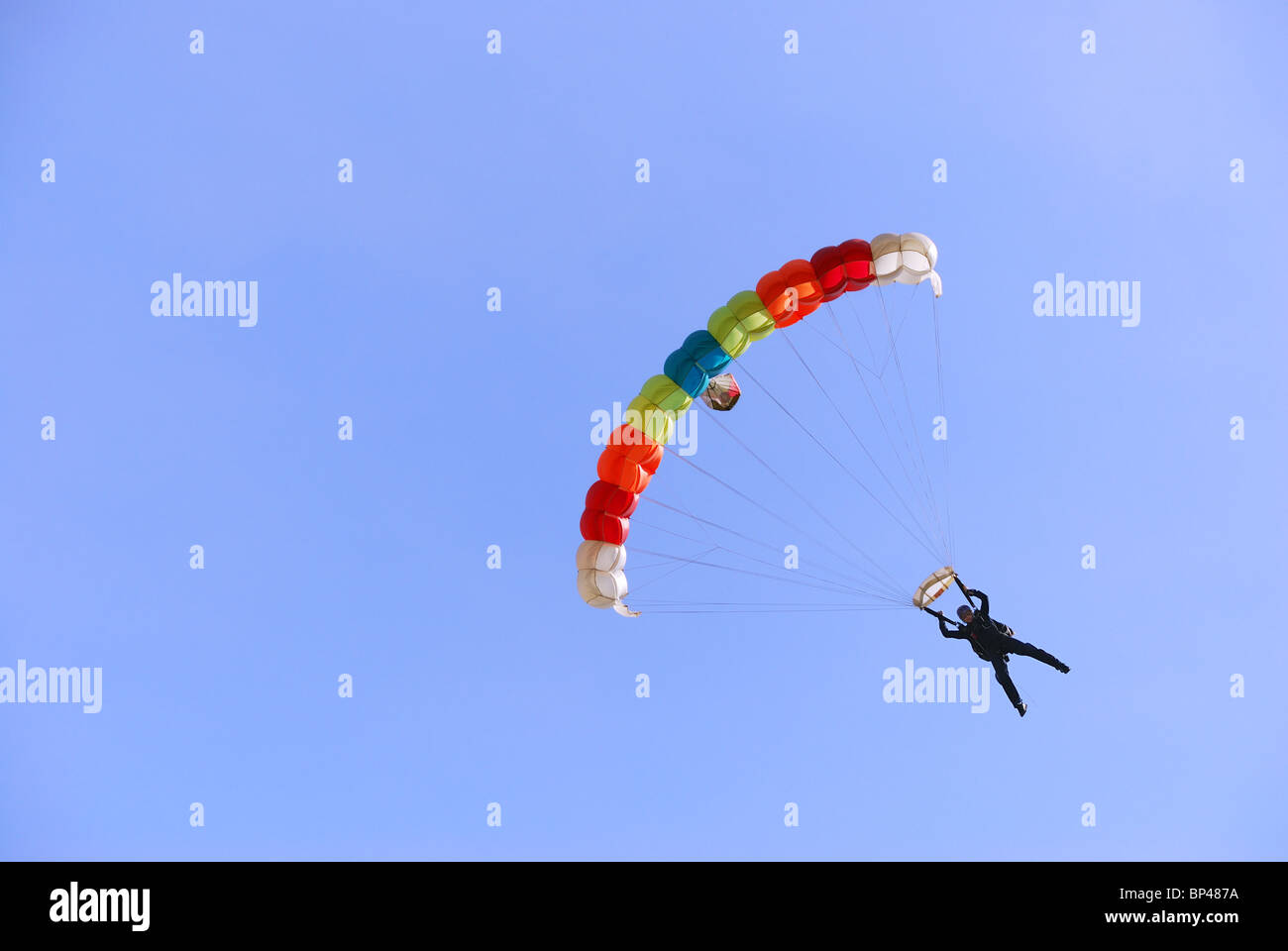 Coloridos paracaídas contra el cielo claro en el fondo. Foto de stock