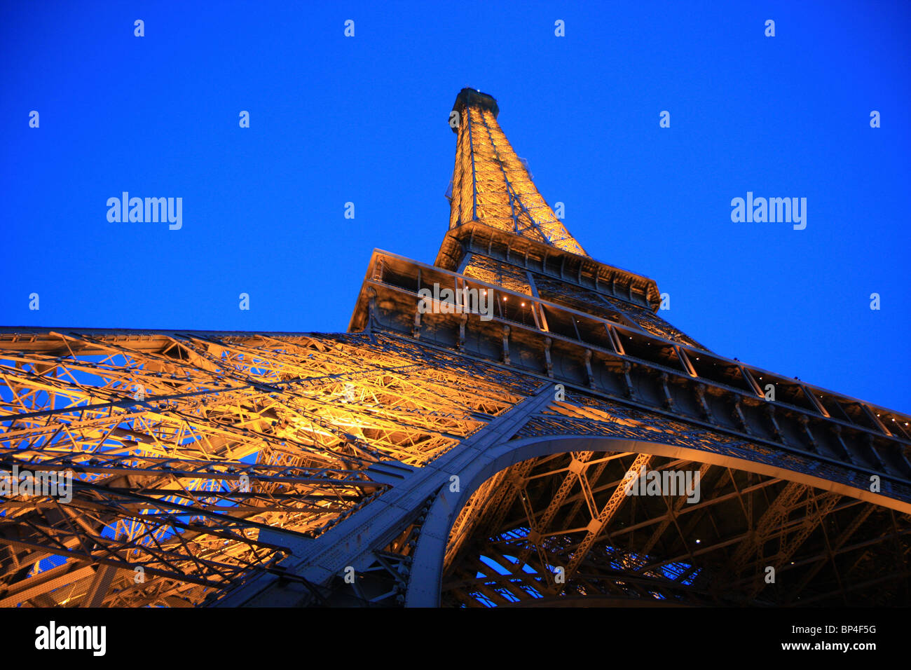 Amplio ángulo de visión de la Torre Eiffel desde abajo en la noche, París, Francia Foto de stock