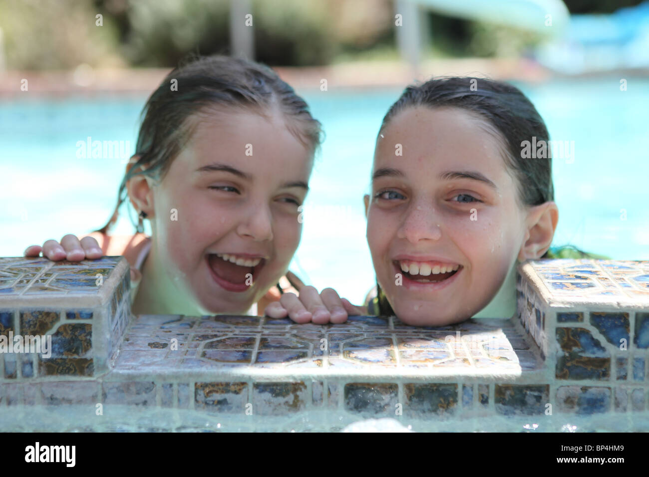Dos Hermanas divirtiéndose en una piscina riendo Fotografía de stock - Alamy