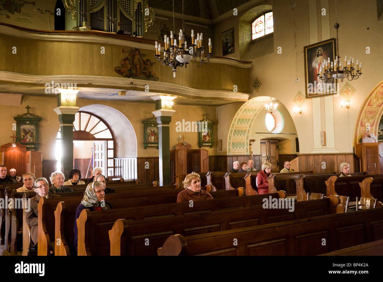 Personas que rezan. Iglesia de la Exaltación de la Santa Cruz, Zwolen Polonia. Foto de stock