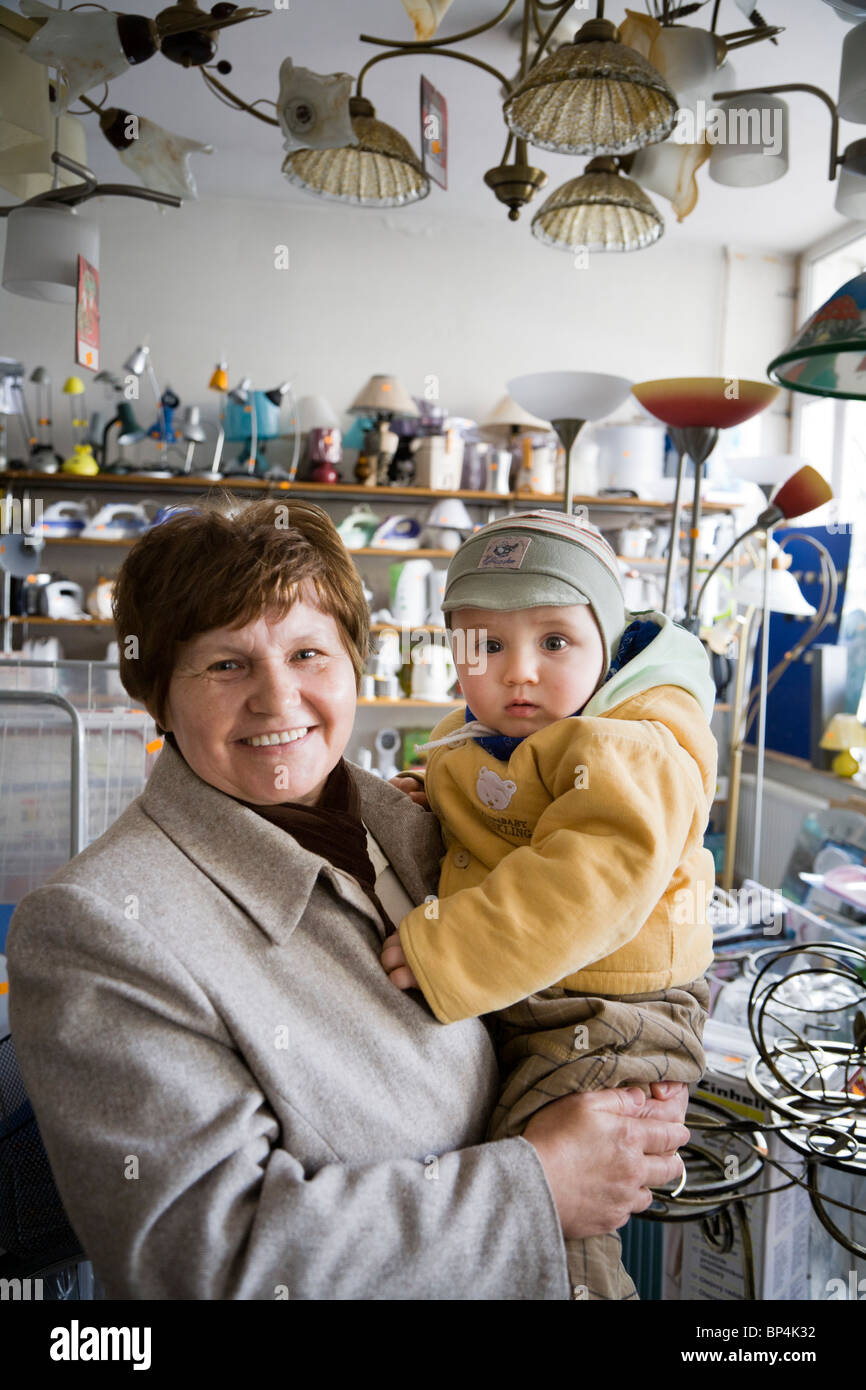 Mujer con su nieto en una pequeña tienda de electrónica. Zwolen Polonia. Foto de stock