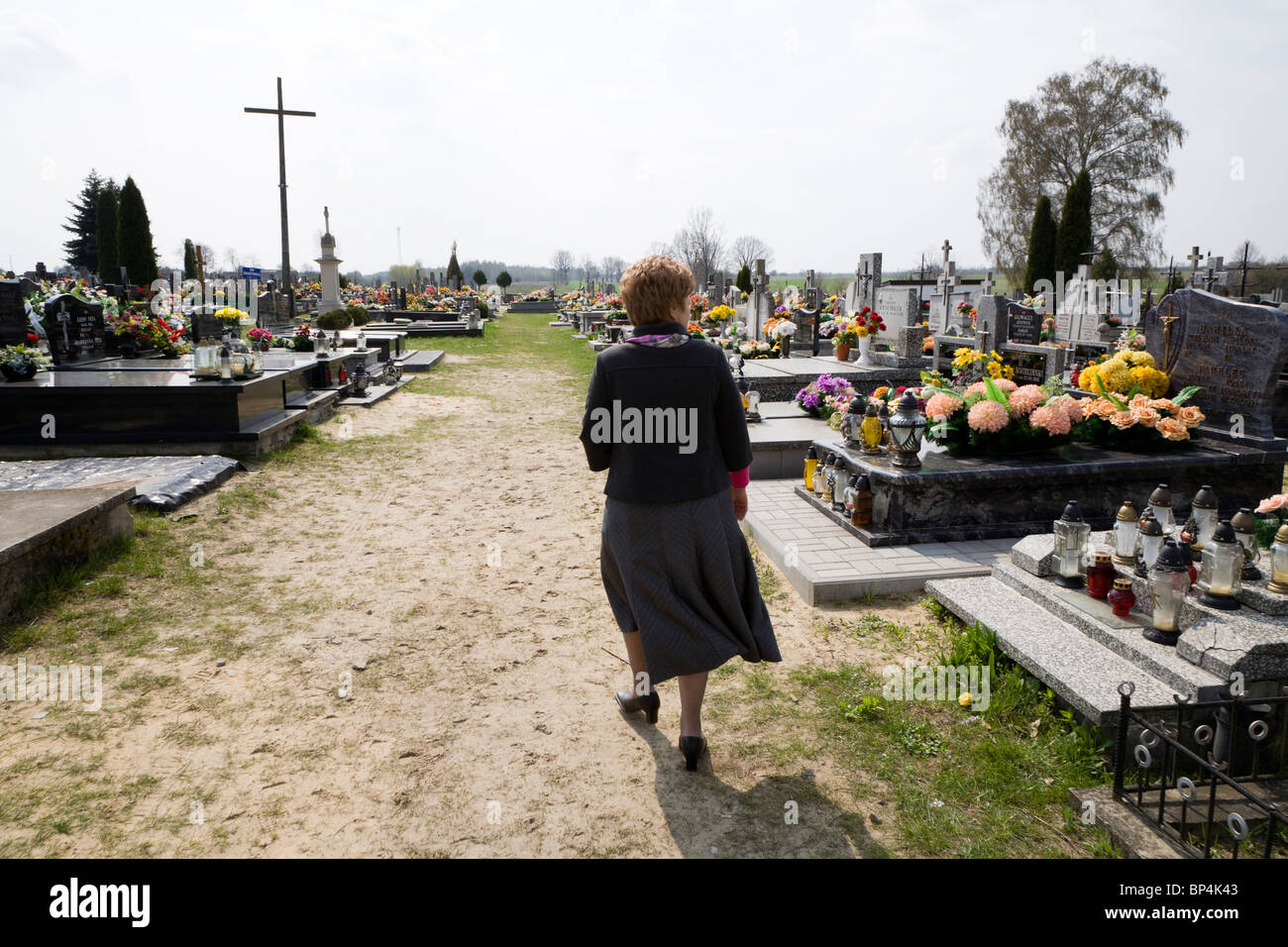 Mujer busca la tumba de un ser querido en un cementerio. Gmina Przylek Zwolen, condado, Polonia. Foto de stock