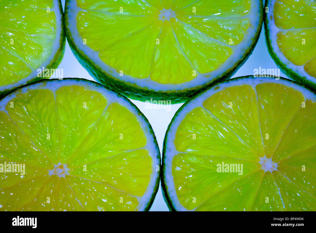 Cortar las limas haciendo un atractivo patrón con luz que brilla a través de la carne Foto de stock