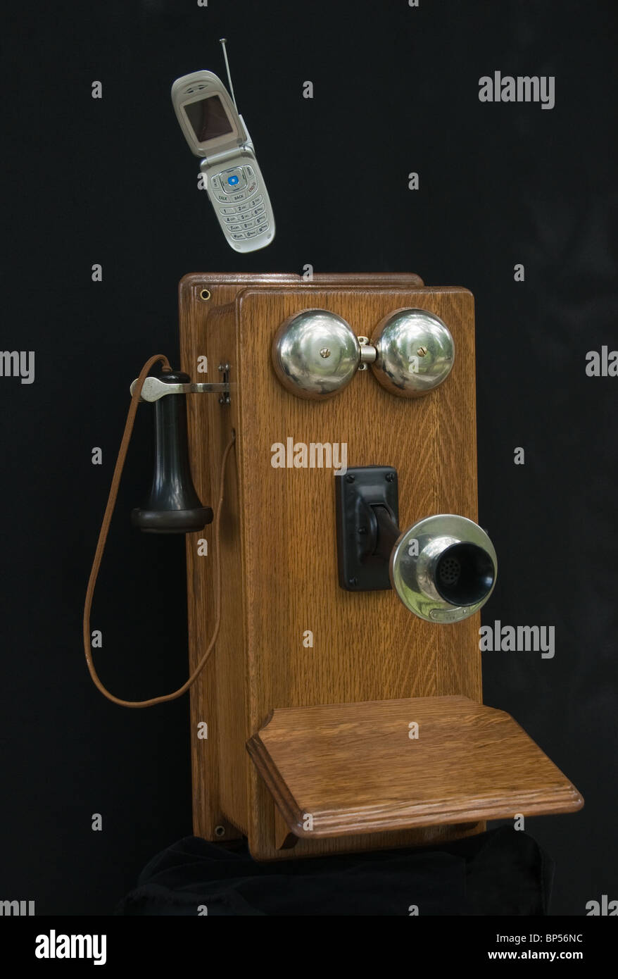 Antiguo teléfono de pared de madera con teléfono celular muestra Foto de stock