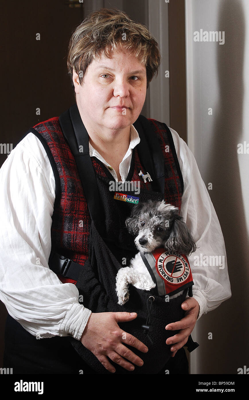 Servicio de mujer con su perro que viste en un arnés para ayudarla con el Trastorno de Estrés Postraumático Foto de stock