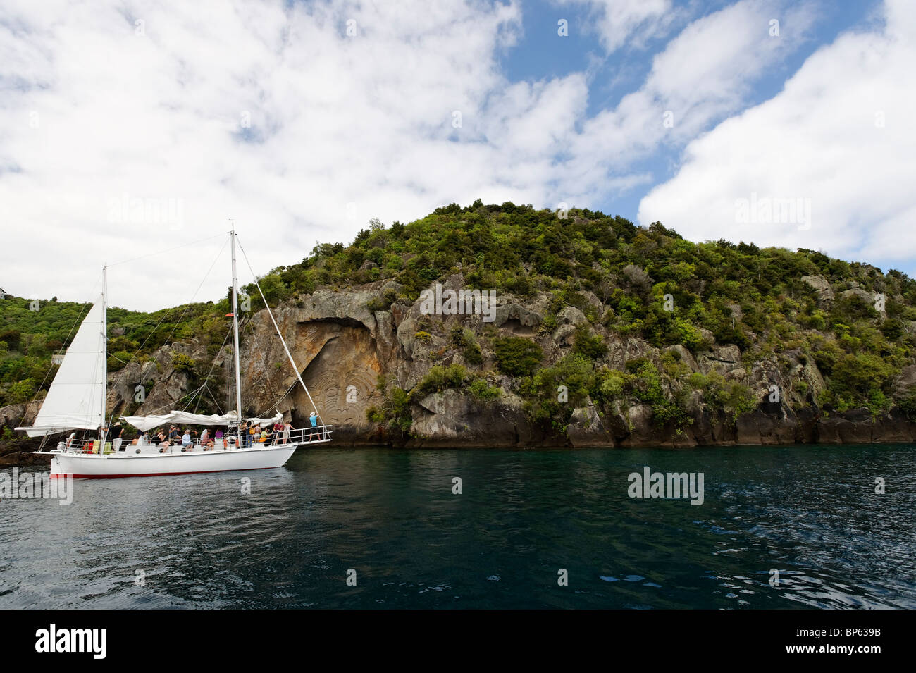 Un Yate turístico en la mina bay tallas en las rocas en el Lago Taupo, Nueva Zelanda Foto de stock