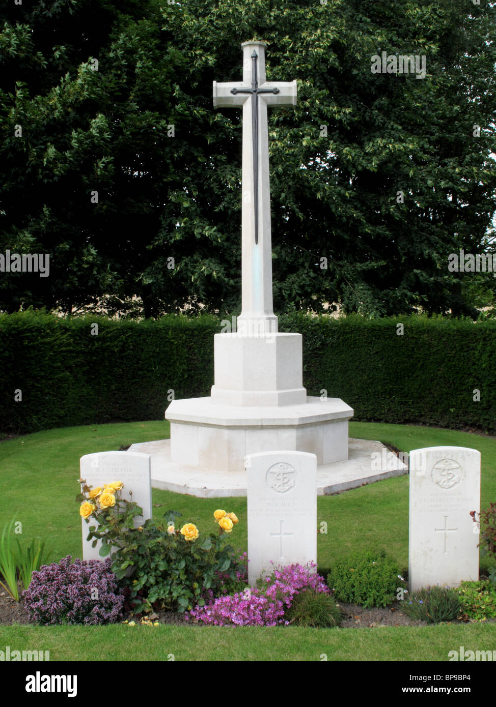 Segunda guerra mundial cross memorial de pie detrás de una fila de lápidas de la marina y la RAF hombres que murieron durante la guerra. Foto de stock