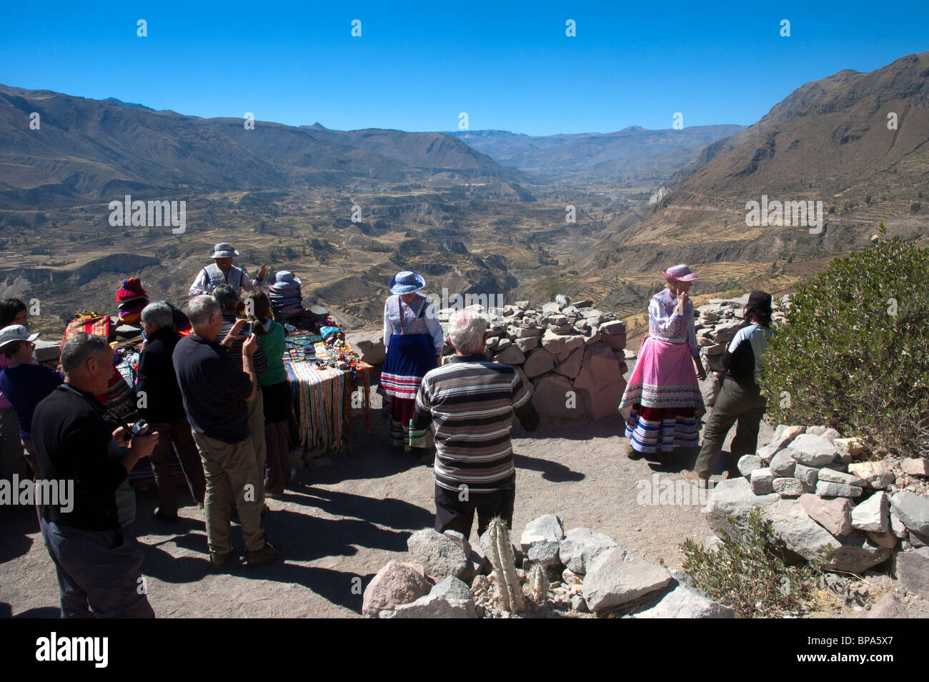 Los turistas occidentales llevan trajes locales en un mirador en el Cañón del Colca, Perú. Foto de stock