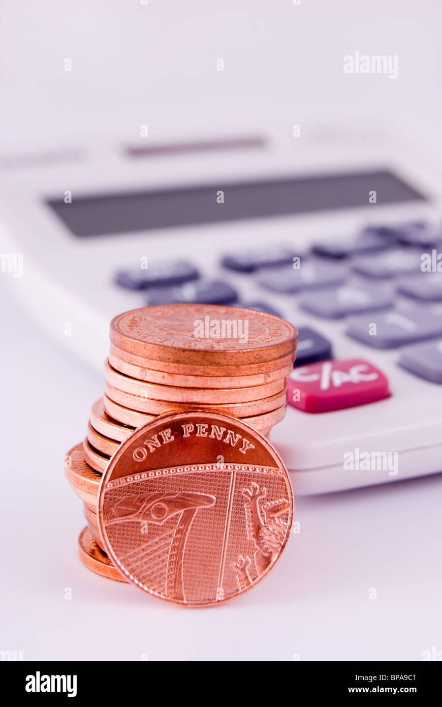 Las monedas de un centavo por una calculadora. Foto de stock