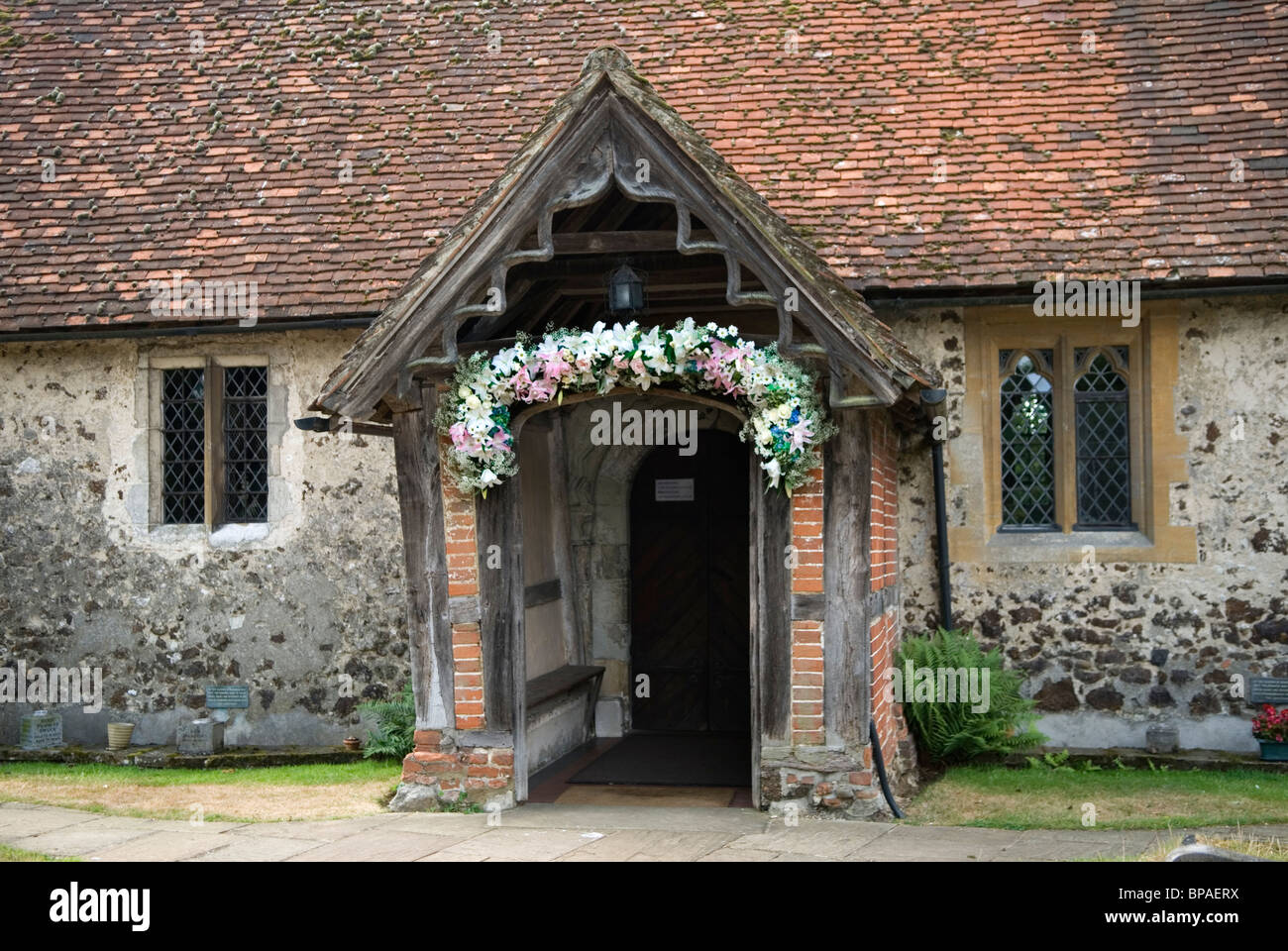 Pyrford Iglesia de San Nicolás. Surrey, Inglaterra. La puerta de la Iglesia decorado con flores para bodas, Inglaterra. Foto de stock