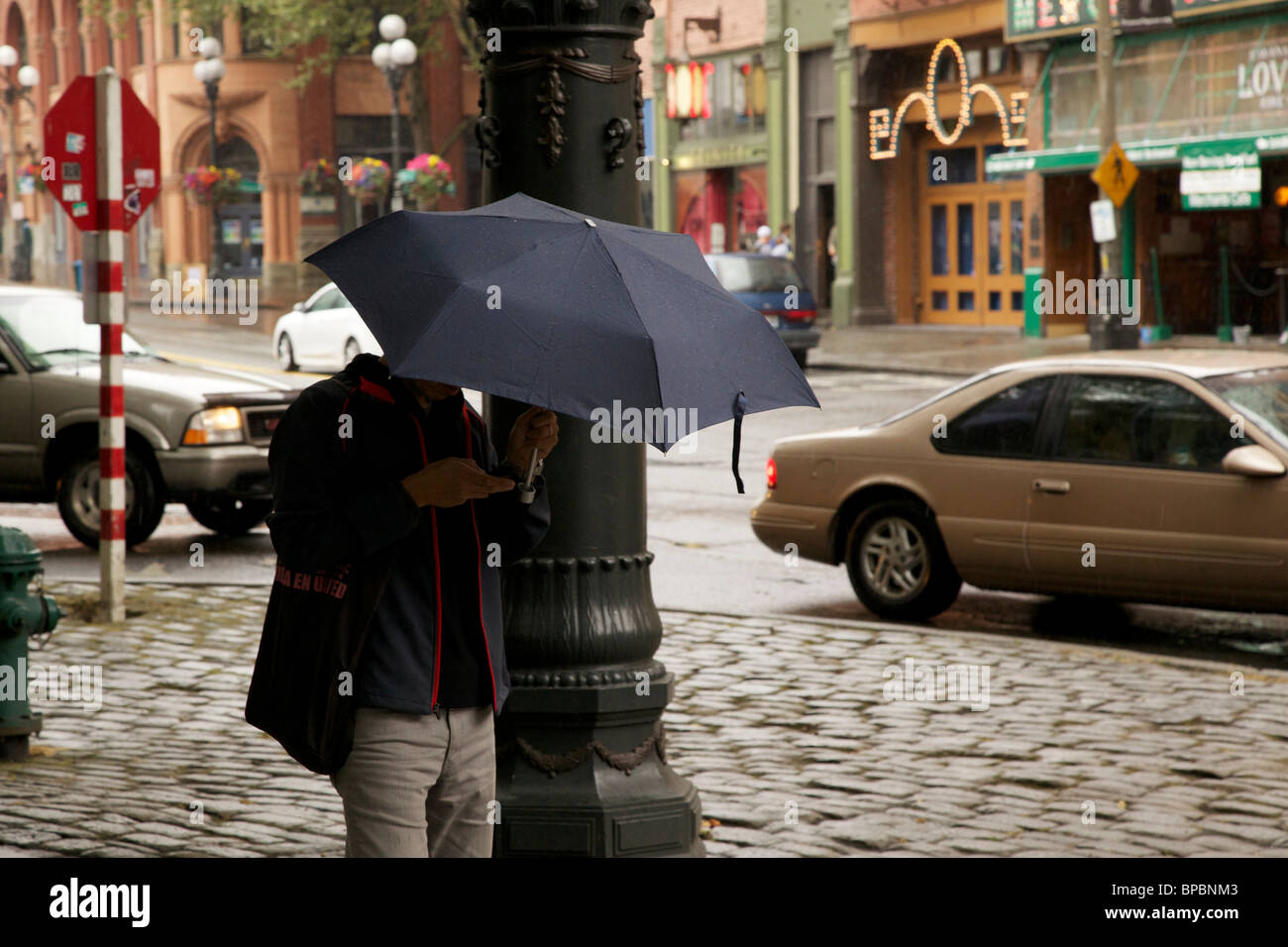 Hombre utilizando teléfono celular la celebración de paraguas. Pioneer  Square, Seattle, Washington Fotografía de stock - Alamy