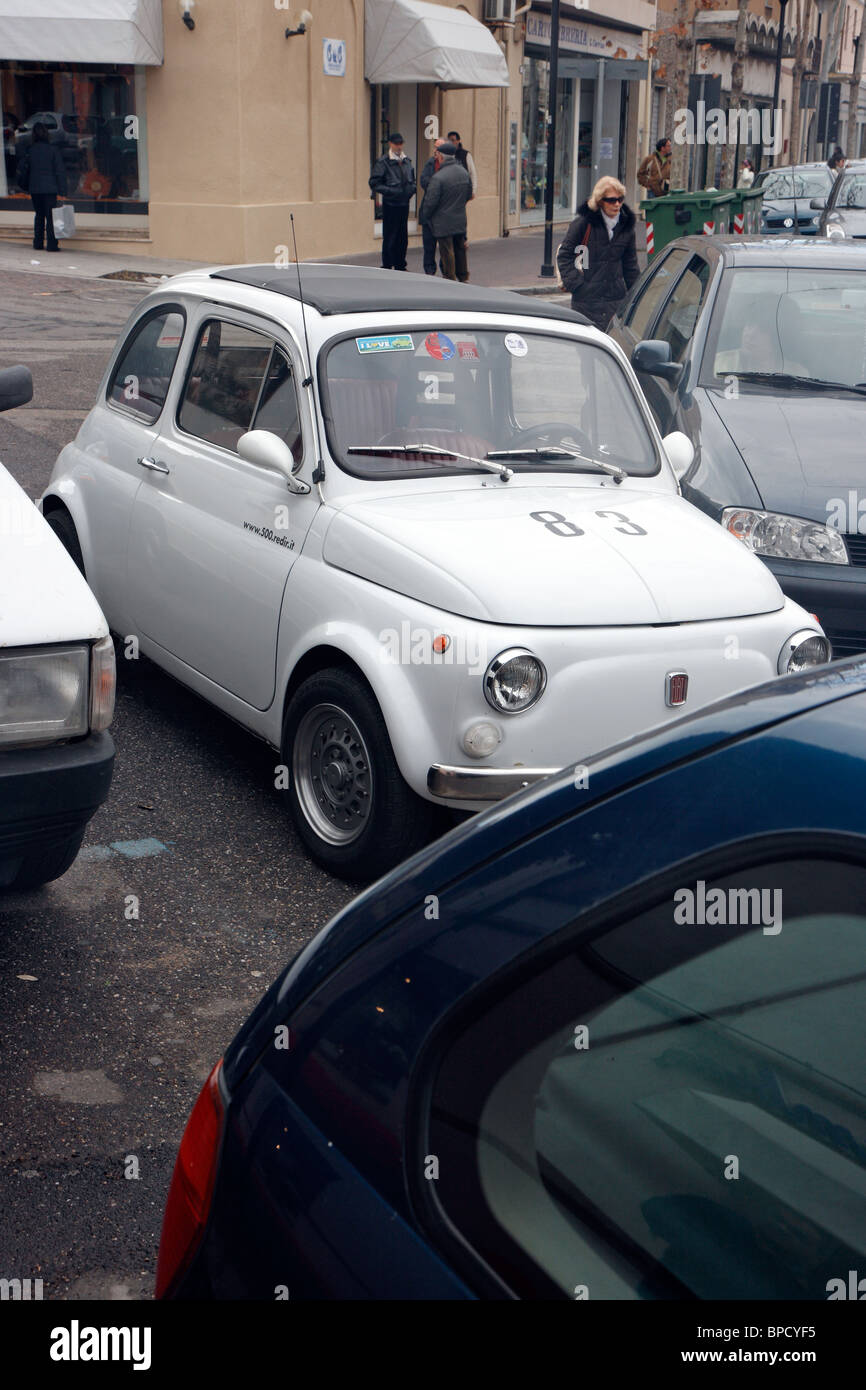 Un coche pequeño Fiat 500 estacionado en una segunda fila, Oristano, Italia Foto de stock