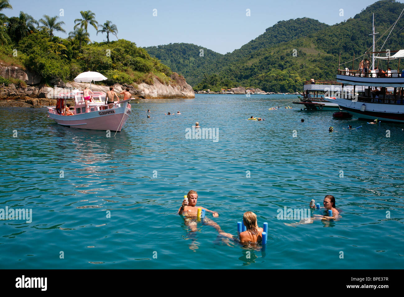 Turista sobre un barco de pesca fletado, navegando entre las diferentes playas e islas alrededor de Parati, Estado de Río de Janeiro Foto de stock