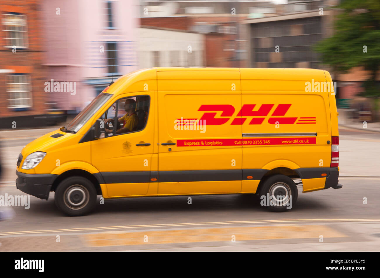 Un amarillo DHL van conduciendo a través de la ciudad que muestran  movimiento en Norwich, Norfolk, Inglaterra, Gran Bretaña, Reino Unido  Fotografía de stock - Alamy