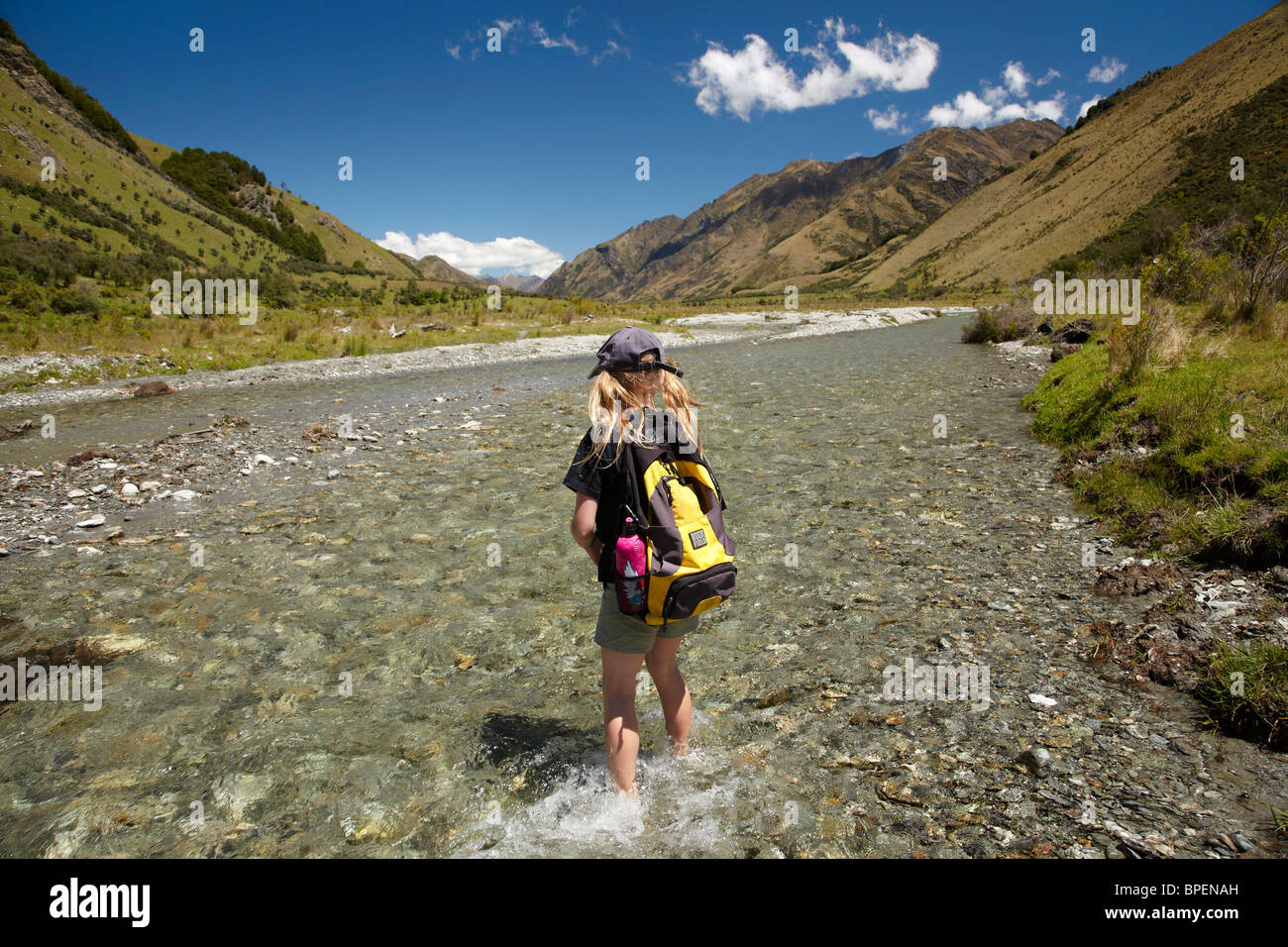 Joven excursionista cruce Moke Creek, Moonlight Vía, cerca de Queenstown, Isla del Sur, Nueva Zelanda Foto de stock