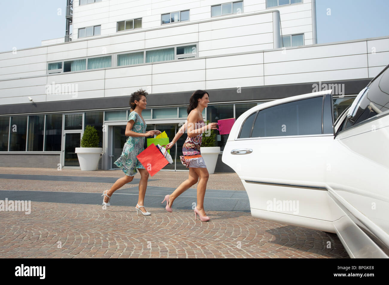 La mujer corriendo al coche con bolsas de la compra. Foto de stock
