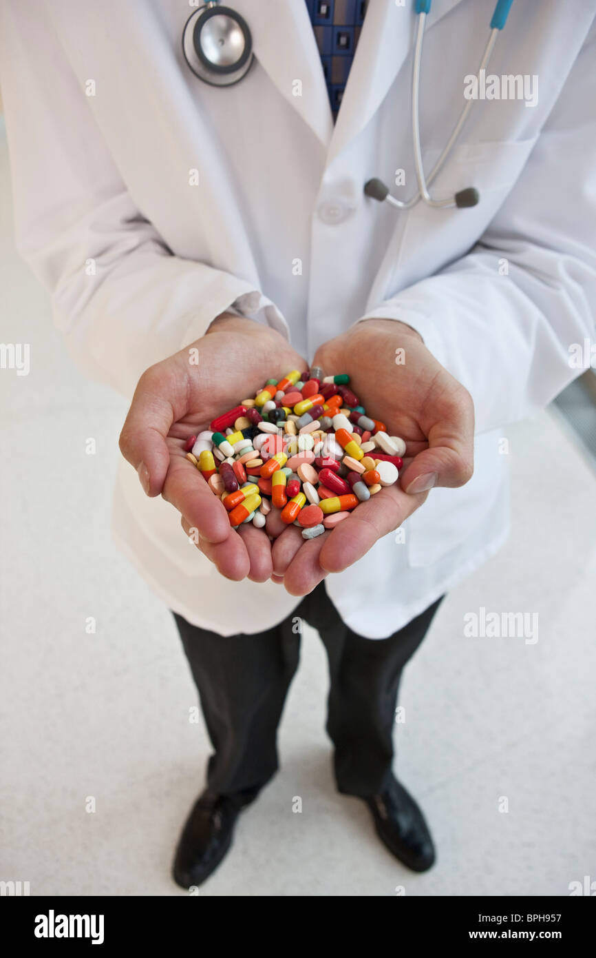 Doctor sosteniendo un puñado de pastillas Foto de stock
