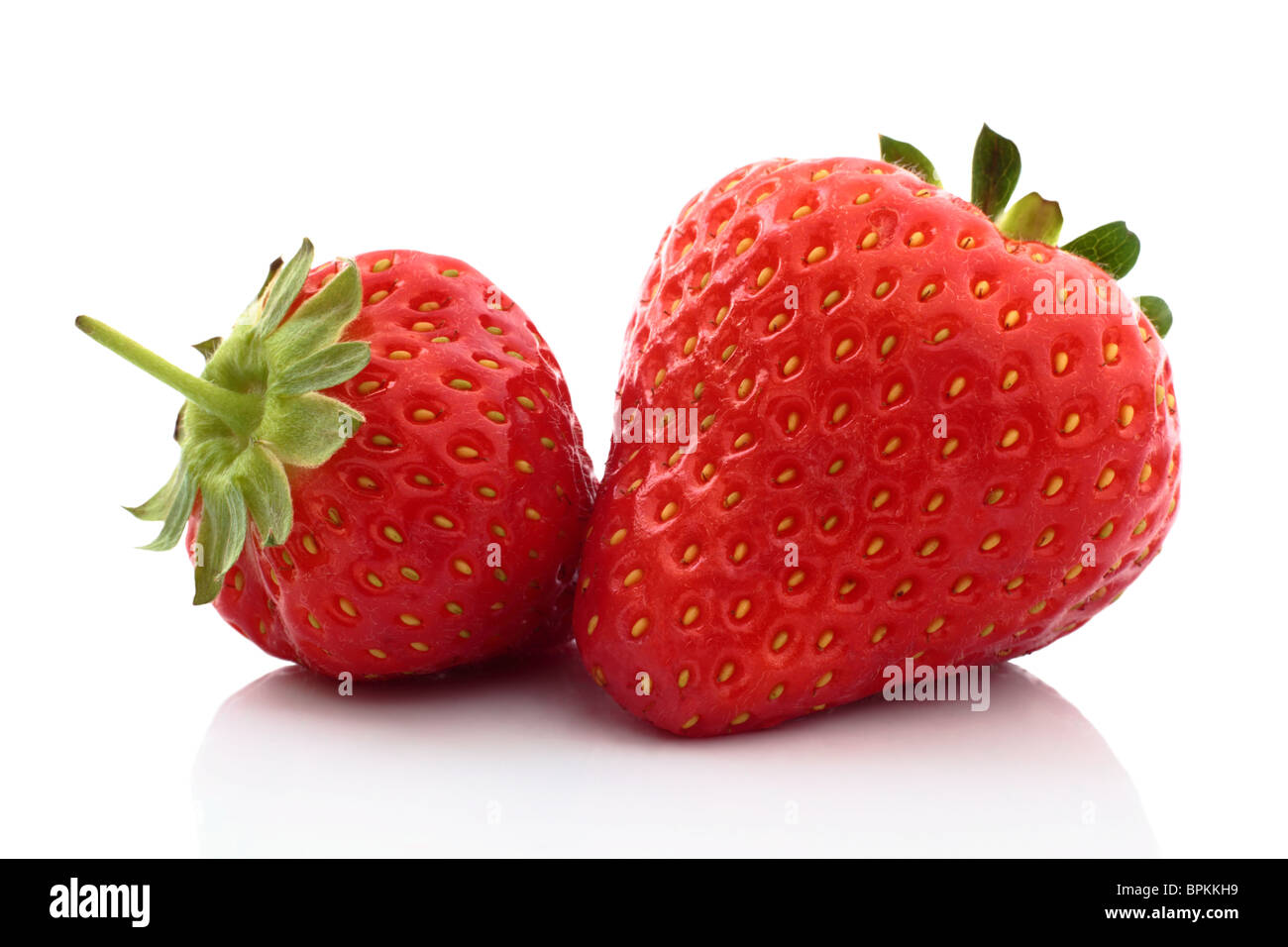 Dos fresas frescas cerrar con una reflexión sobre un fondo blanco. Foto de stock