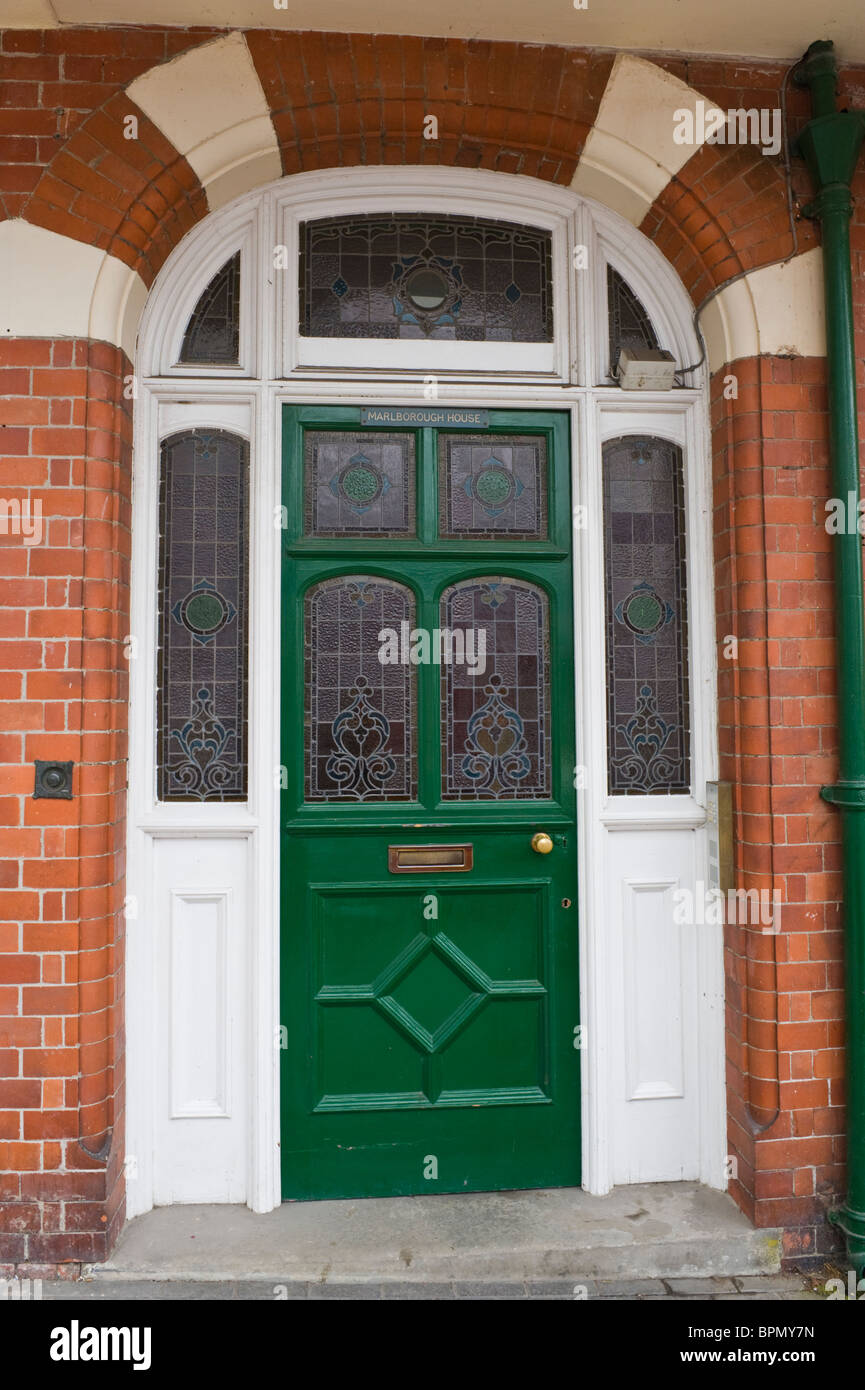 Victoriano pintado de verde con paneles de puerta con vitrales de casa de ladrillo en el centro de Gales Powys Llandrindod Wells UK Foto de stock