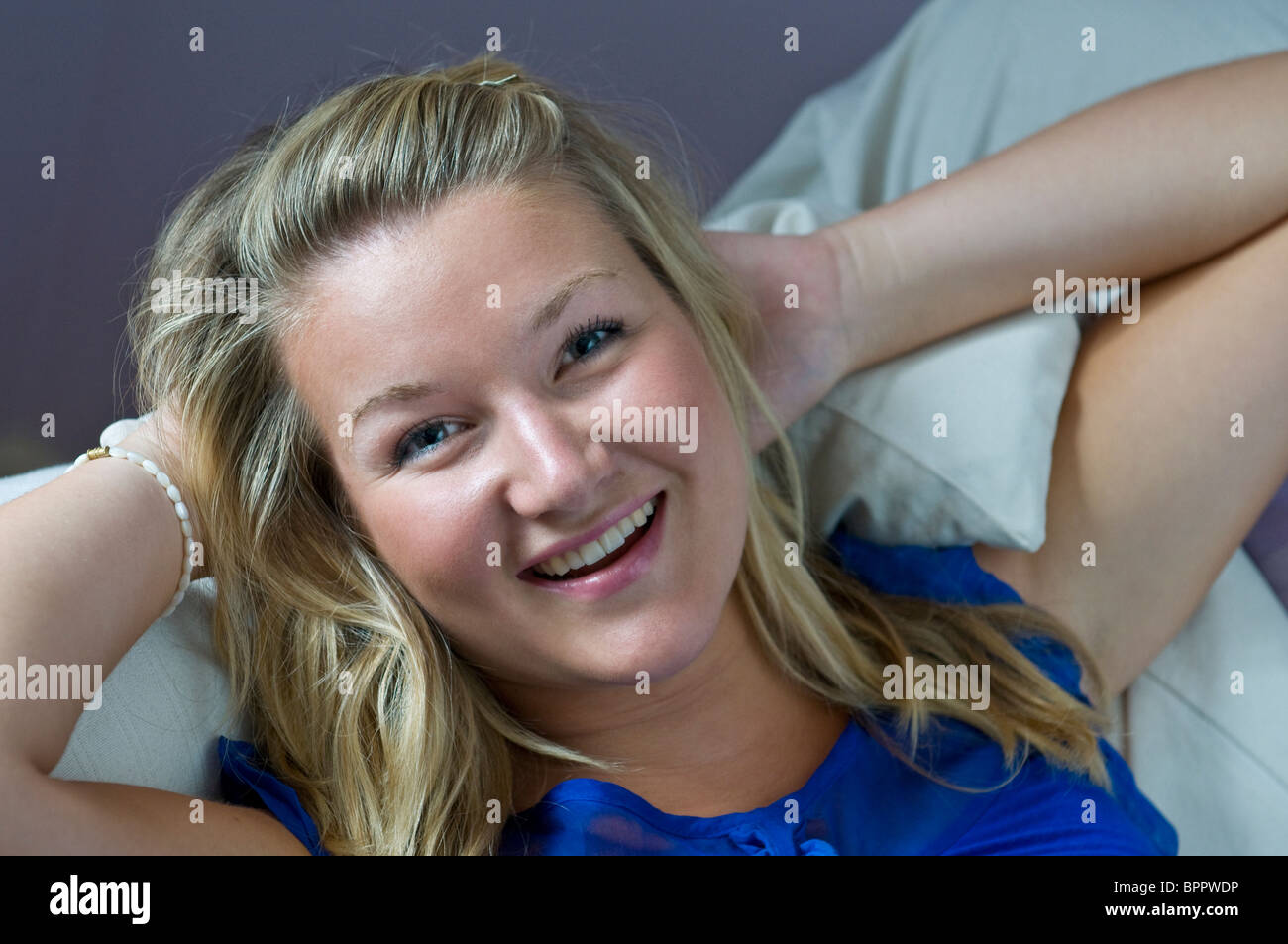 18-20 años animada atractiva chica rubia feliz confiada adolescente descansando en su habitación piso compartido en casa Foto de stock