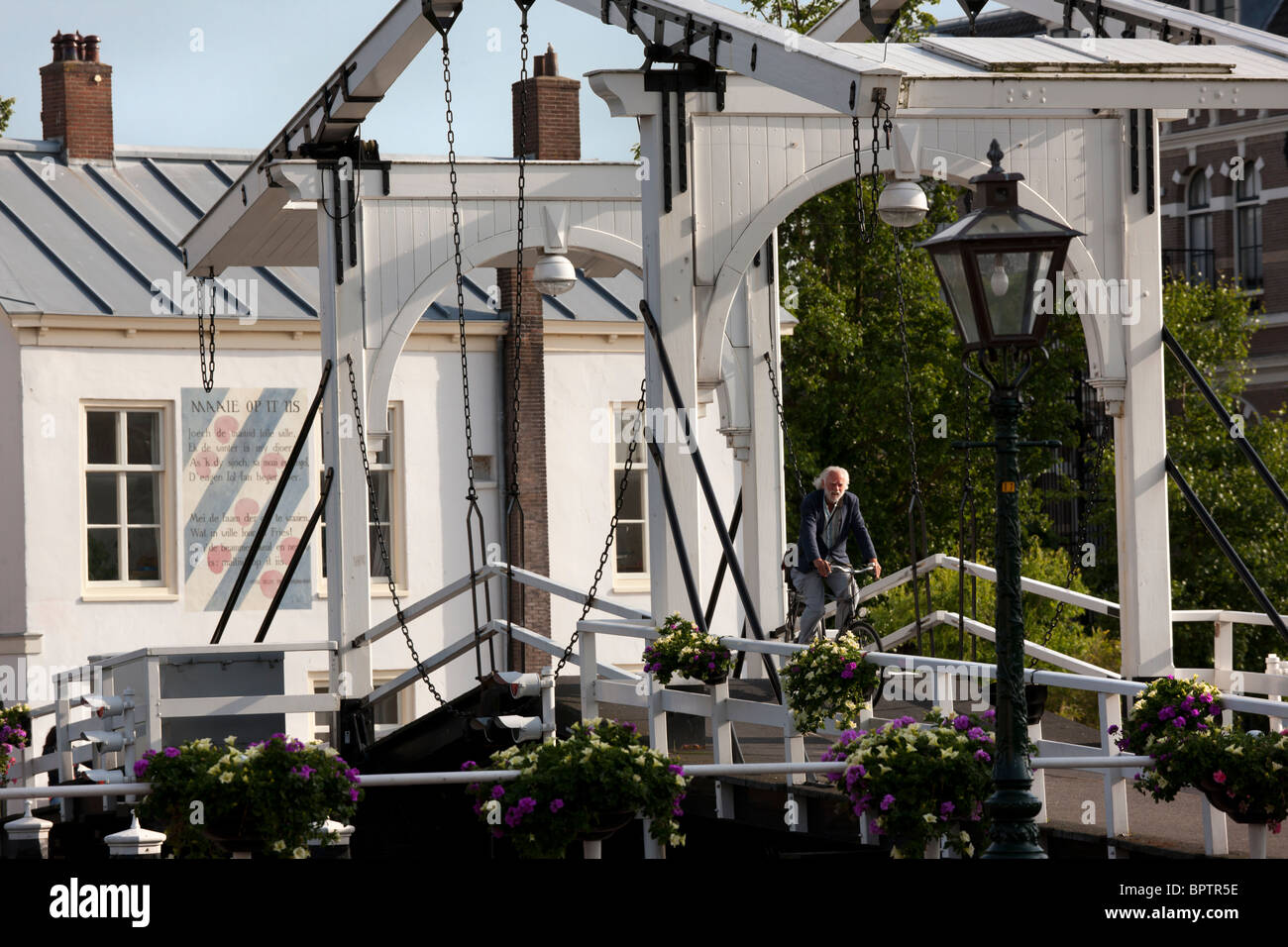 Casco histórico puente Rembrandt Rembrandtbrug doble puente levadizo con ciclista, hombre sobre una bicicleta, en Leiden, Leiden, Países Bajos Foto de stock